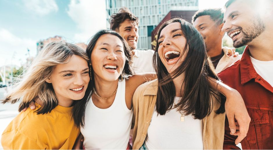 Group of friends laughing together while walking outdoors.